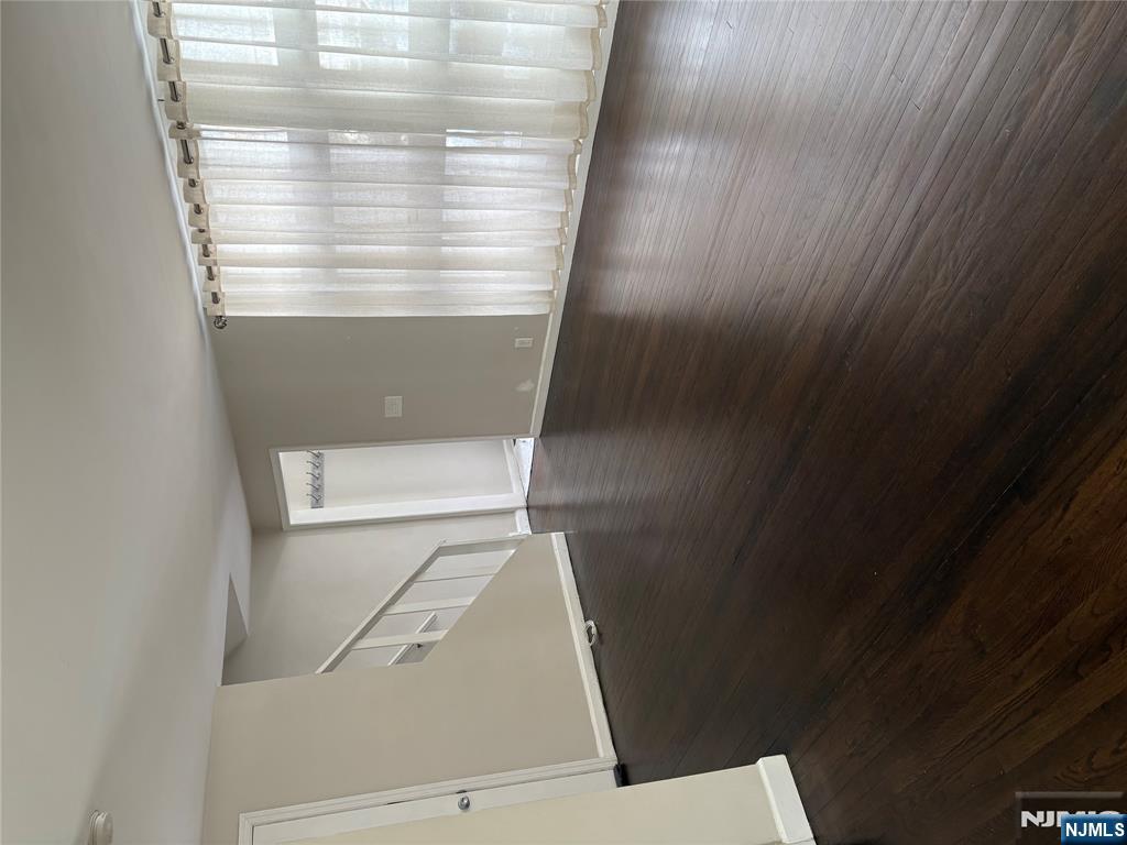 66 Stuart Street, Unit B Waldwick, NJ 07463 - Photo 2 of 11 a view of an empty room with wooden floor and a window