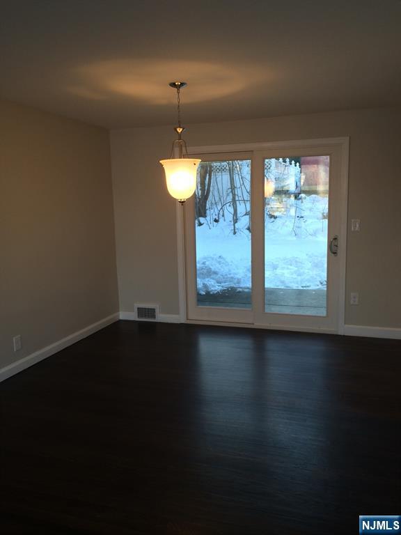 66 Stuart Street, Unit B Waldwick, NJ 07463 - Photo 5 of 11 an empty room with wooden floor and windows