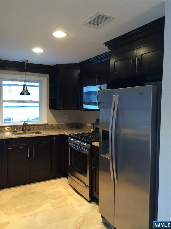 66 Stuart Street, Unit B Waldwick, NJ 07463 - Photo 6 of 11 a kitchen with stainless steel appliances granite countertop a refrigerator a sink and a stove