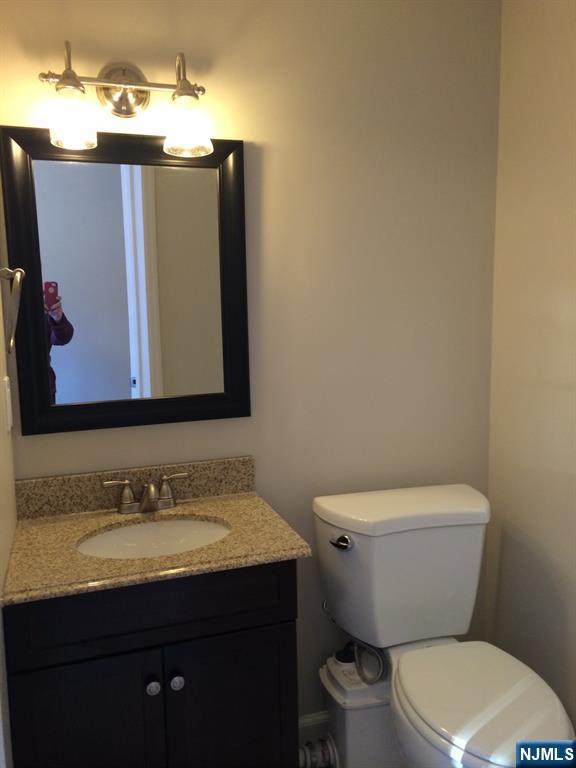 66 Stuart Street, Unit B Waldwick, NJ 07463 - Photo 10 of 11 a bathroom with a granite countertop toilet sink and mirror