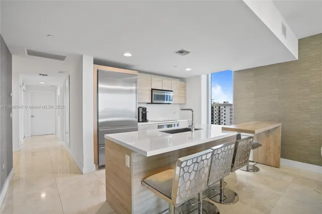 a kitchen with kitchen island a sink stove and refrigerator