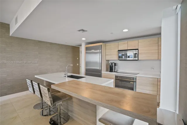 a kitchen with a sink a clock and cabinets