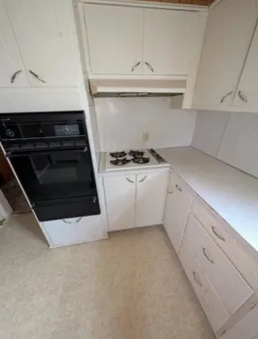 a view of walk in closet with clothes and door