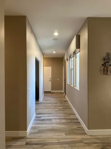 a view of a hallway with wooden floor and staircase