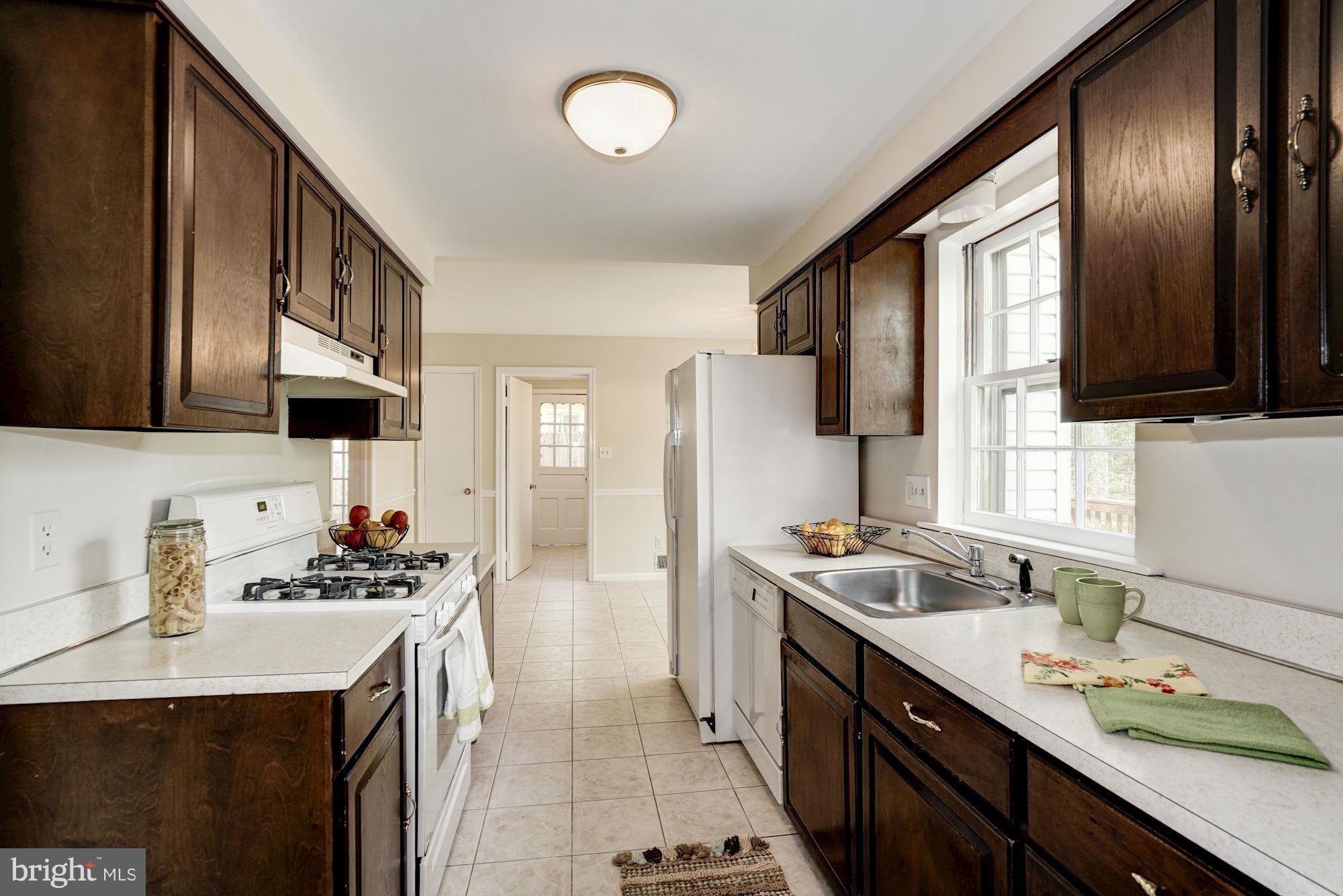11037 Ring Road Reston, VA 20190 - Photo 13 of 30 a kitchen with stainless steel appliances a sink stove and refrigerator