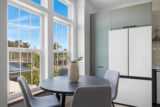 a kitchen with a table chairs refrigerator and wooden cabinets