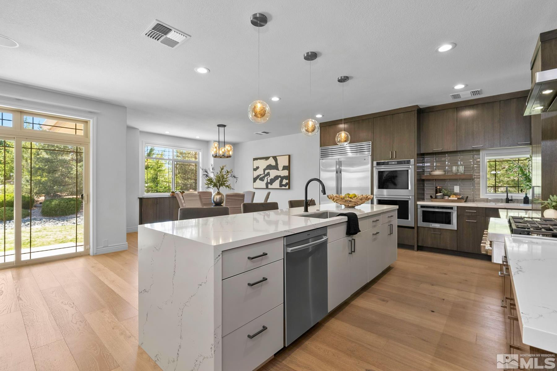 13000 Silver Wolf Road Reno, NV 89511 - Photo 8 of 43 a large kitchen with stainless steel appliances a lot of counter space and a wooden floors