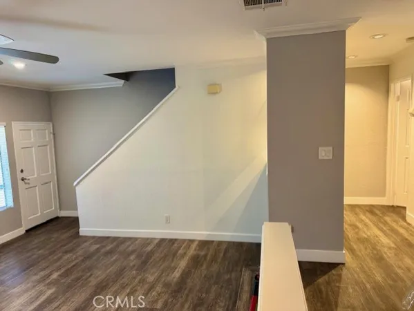 a view of an empty room with wooden floor