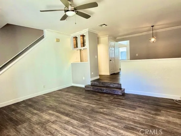 a view of a livingroom with wooden floor and a ceiling fan