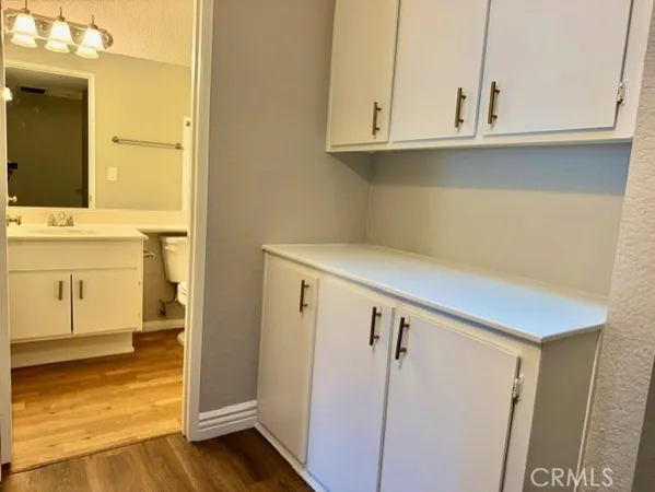 a view of cabinets and utility room with wooden floor