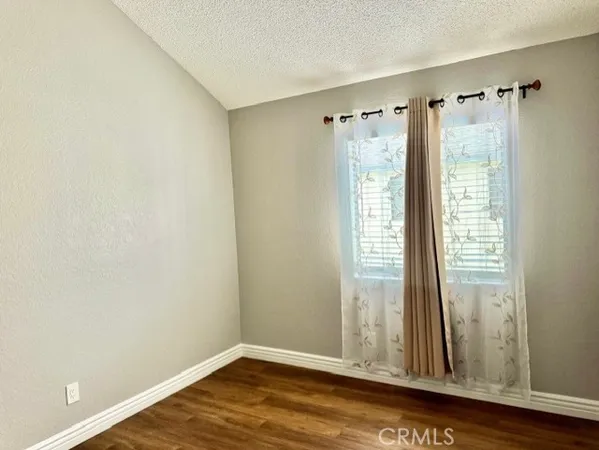a view of a room that has wooden floor and a window