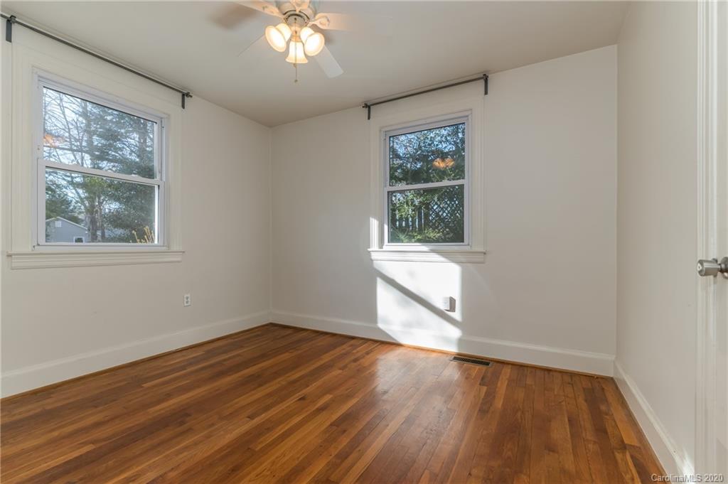 243 Woodland Road Tryon, NC 28782 - Photo 19 of 24 an empty room with wooden floor and windows