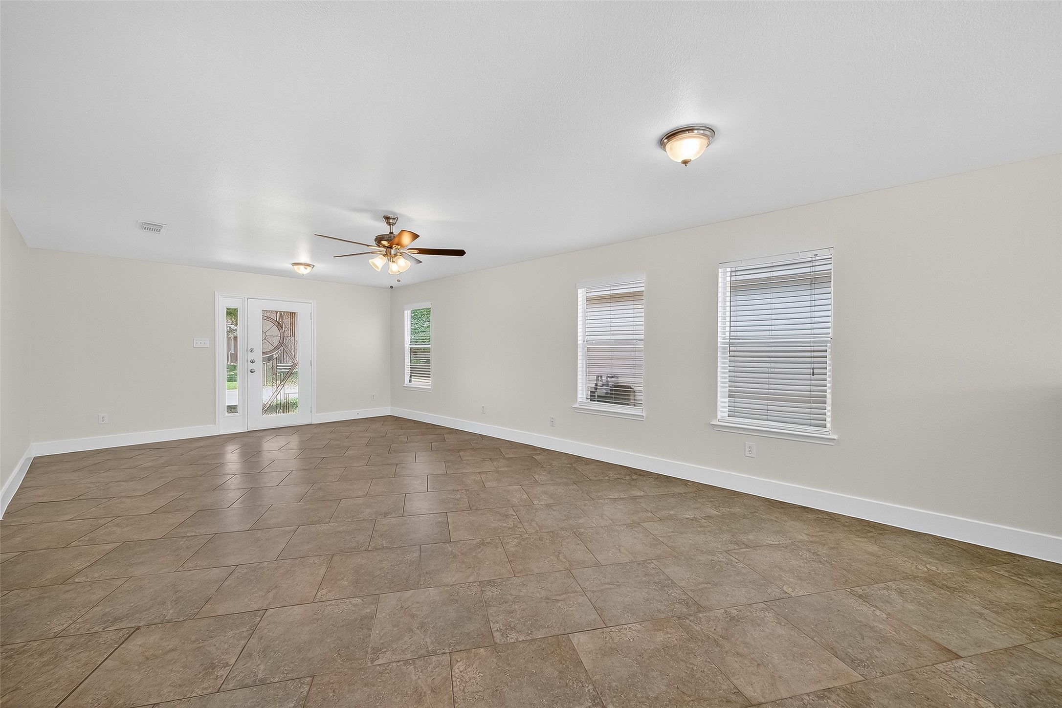 20907 Baronsledge Lane Katy, TX 77449 - Photo 12 of 50 an empty room with chandelier fan and windows
