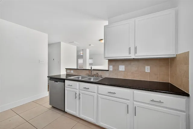 a kitchen with granite countertop white cabinets and a sink