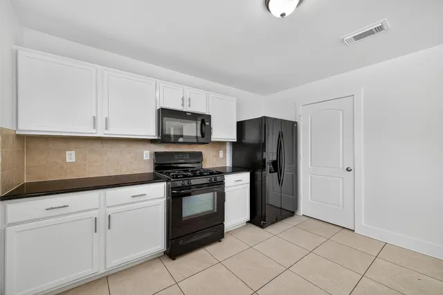 a kitchen with white cabinets stainless steel appliances and a sink