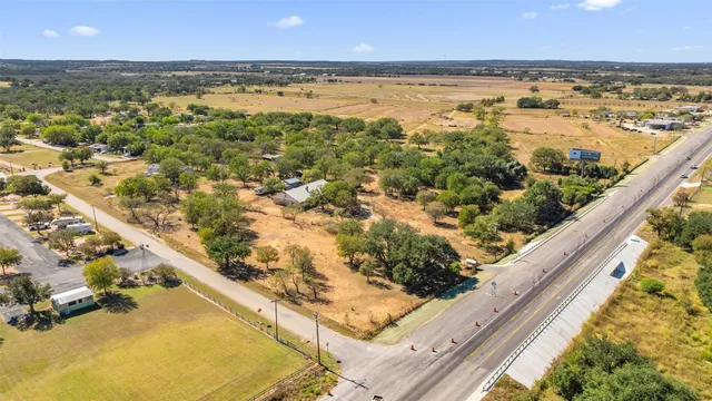 an aerial view of residential houses with outdoor space and trees