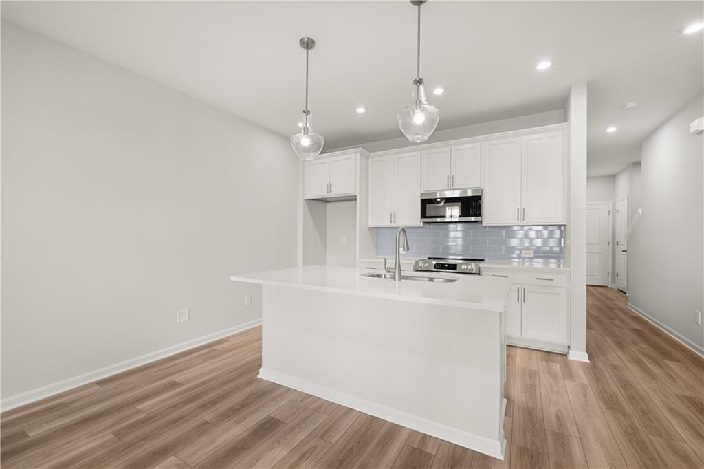 117 Pk Rdg Circle Emerson, GA 30120 - Photo 30 of 49 a kitchen with stainless steel appliances granite countertop a sink a stove a refrigerator and white cabinets with wooden floor