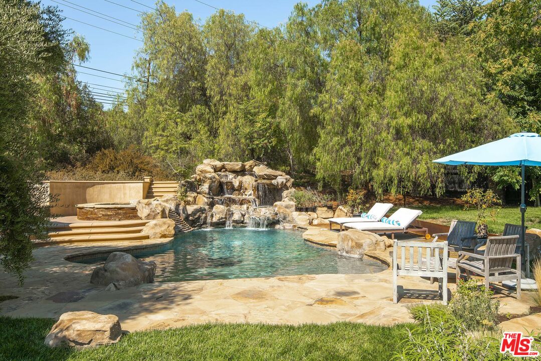 2251 Cold Canyon Road Calabasas, CA 91302 - Photo 33 of 47 a view of swimming pool with lawn chairs under an umbrella