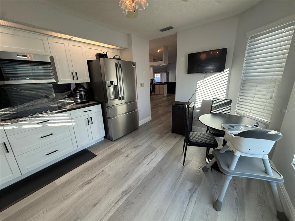 10400 Casa Grande Circle Spring Hill, FL 34608 - Photo 11 of 55 a kitchen with stainless steel appliances a stove a refrigerator and a microwave