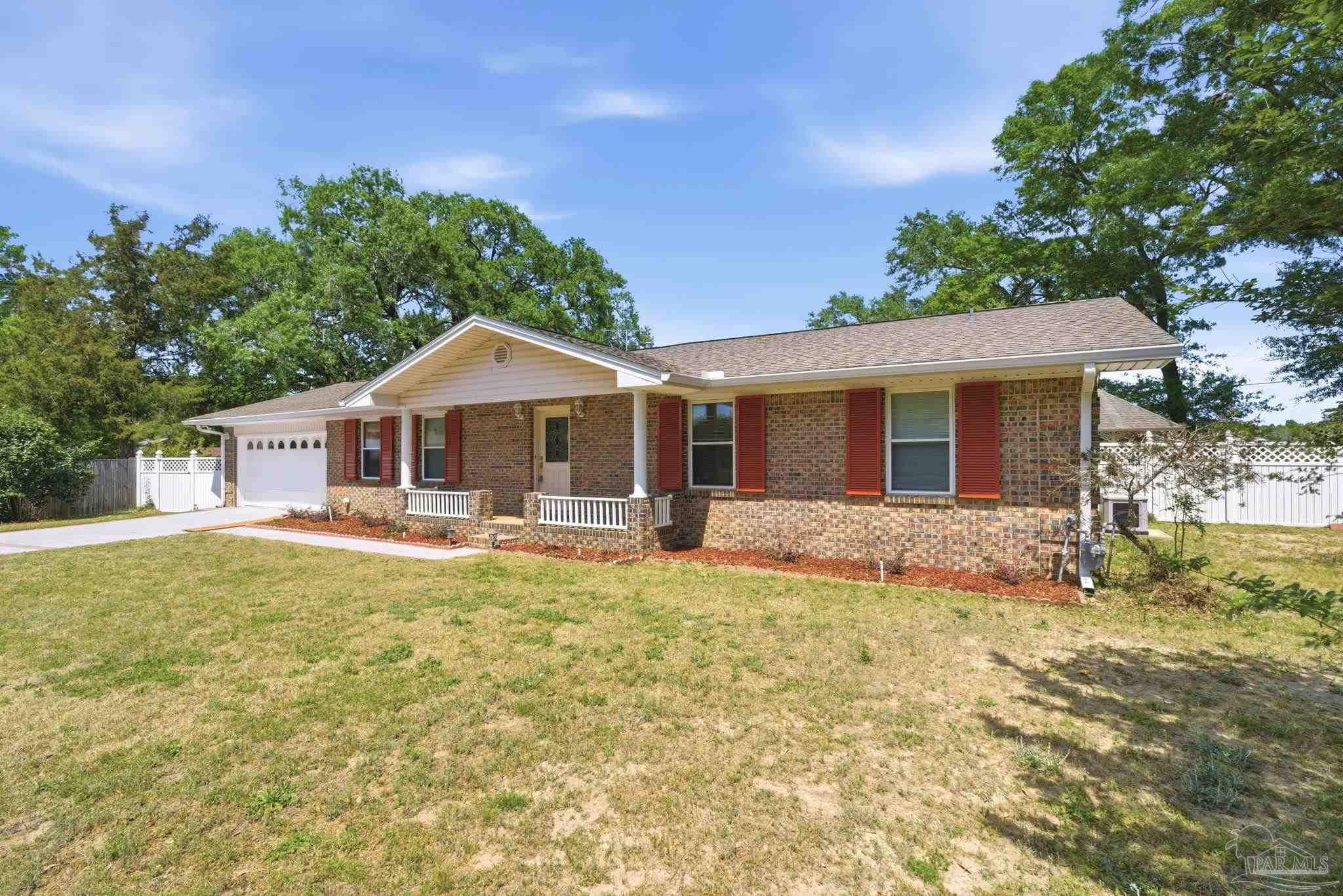 4320 Grant Street Pace, FL 32571 - Photo 1 of 27 a front view of a house with a garden and porch