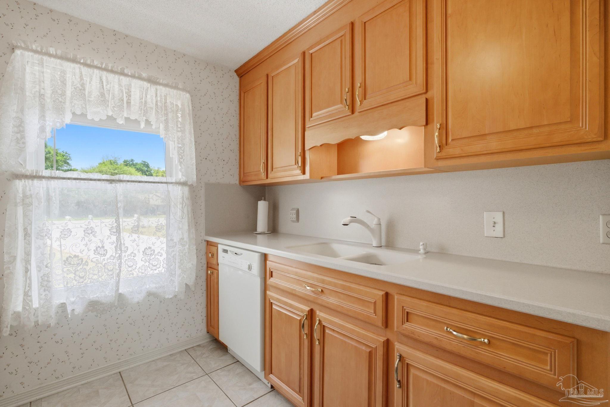 4320 Grant Street Pace, FL 32571 - Photo 14 of 27 a kitchen with stainless steel appliances granite countertop a sink and dishwasher with cabinets