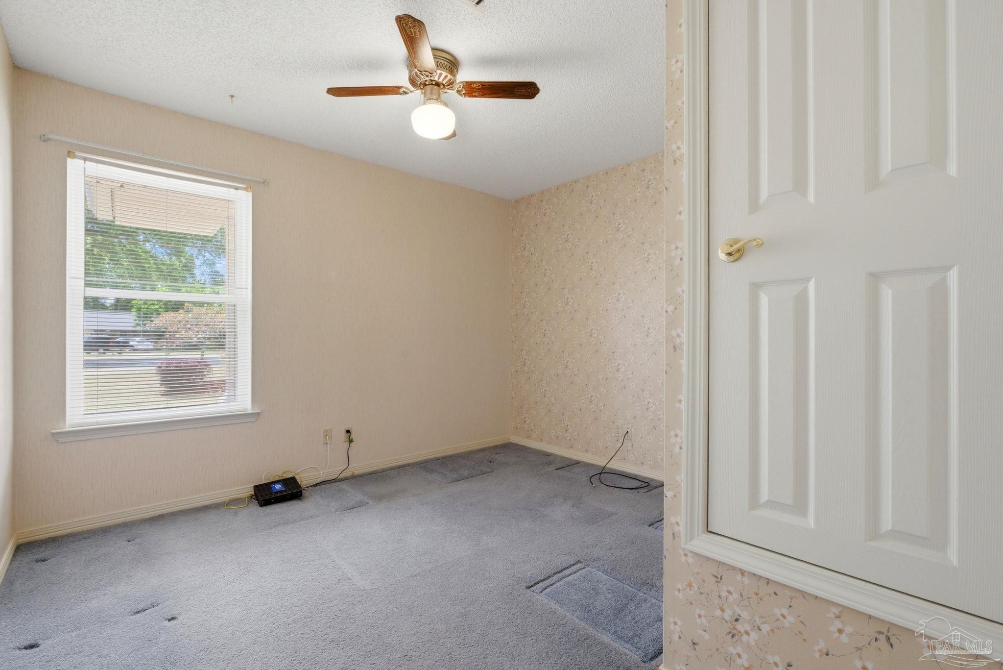 4320 Grant Street Pace, FL 32571 - Photo 16 of 27 an empty room with windows and ceiling fan