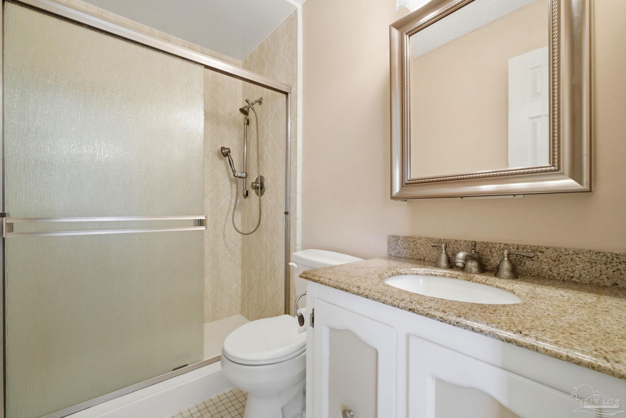 4320 Grant Street Pace, FL 32571 - Photo 24 of 27 a bathroom with a granite countertop shower sink vanity and toilet