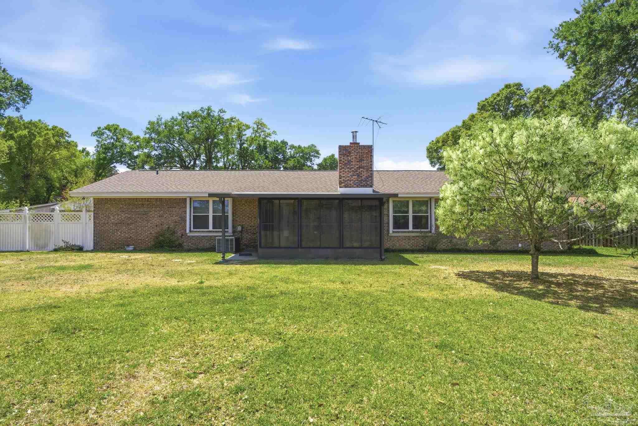 4320 Grant Street Pace, FL 32571 - Photo 26 of 27 a backyard of a house with lots of green space