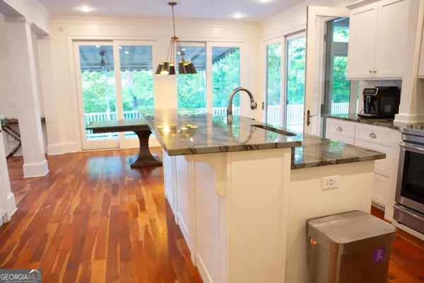a kitchen with stainless steel appliances granite countertop a stove a sink dishwasher a refrigerator and a microwave