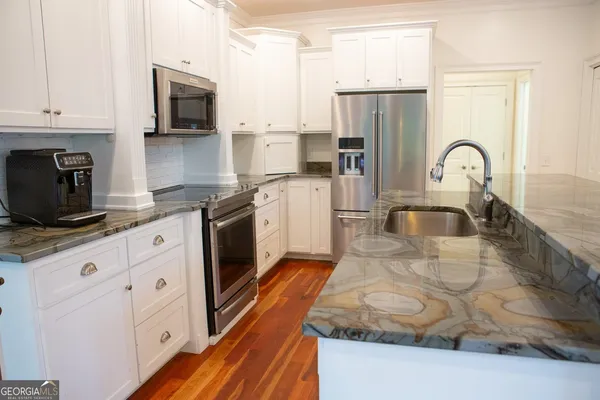 a kitchen with stainless steel appliances granite countertop a stove a sink and a microwave