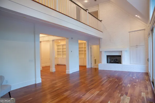 a view of a room with wooden floor and windows