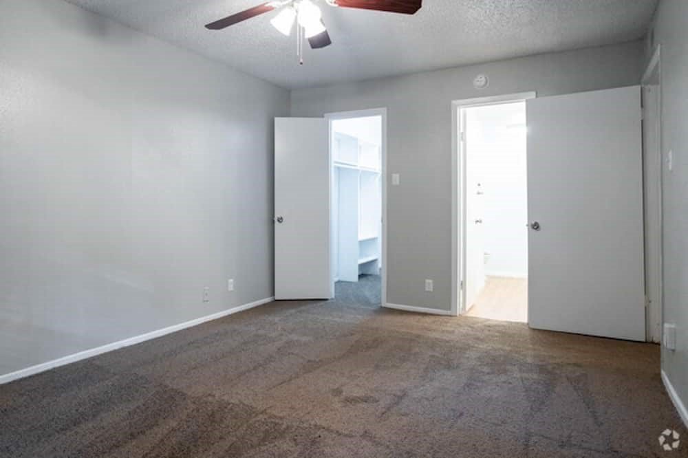 6505 Westheimer Road, Unit 118 Houston, TX 77057 - Photo 12 of 16 an empty room with a chandelier fan and windows