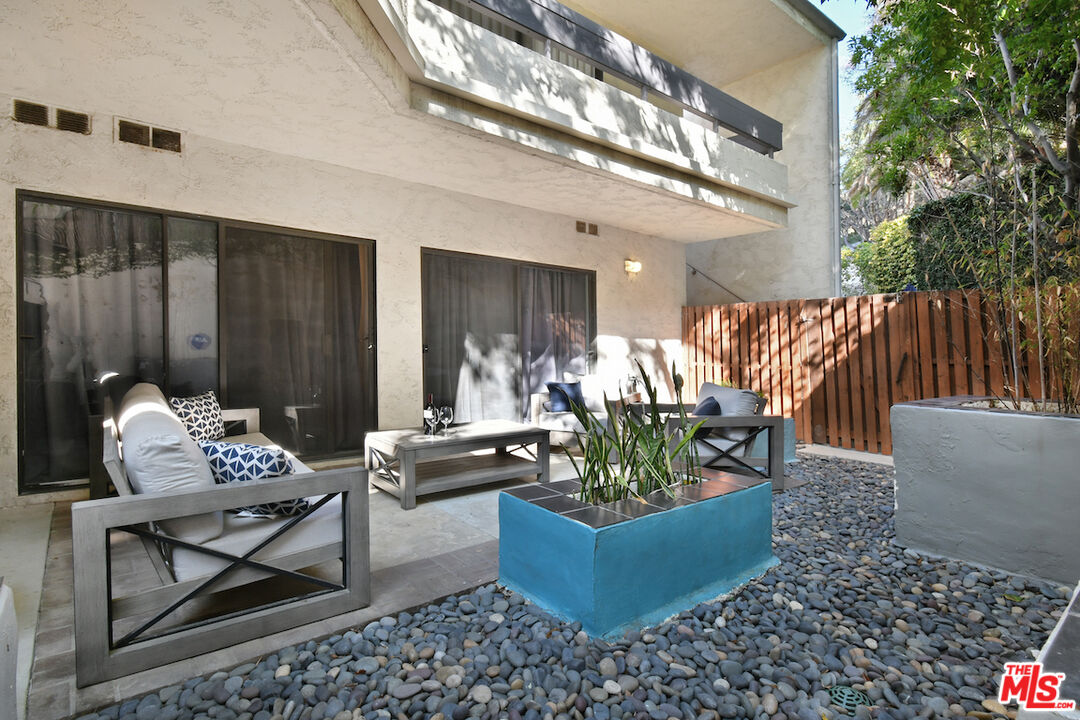 11687 Bellagio Road, Unit 3 Los Angeles, CA 90049 - Photo 46 of 57 a living room with couches chairs and a dining table with wooden floor