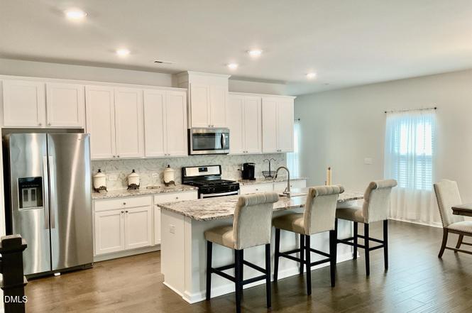 1807 Wrenn Road Durham, NC 27703 - Photo 14 of 43 a kitchen with stainless steel appliances granite countertop a table chairs microwave and sink