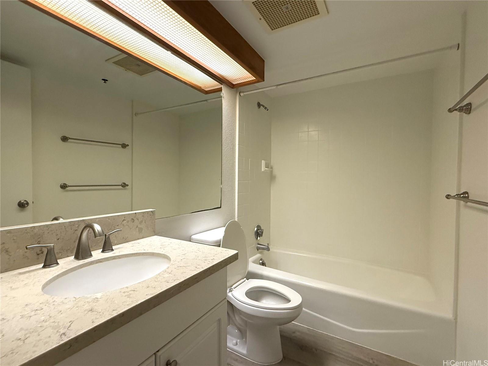 5333 Likini Street, Unit 1008 Honolulu, HI 96818 - Photo 5 of 17 a bathroom with a granite countertop sink toilet mirror and bathtub