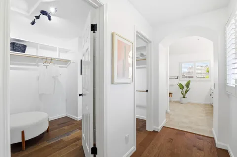 a view of a hallway with wooden floor and closet area