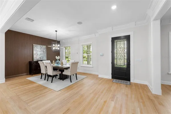 a large white kitchen with a large island oven a stove and a wooden floor
