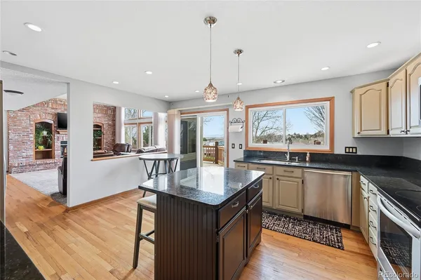 a kitchen with stainless steel appliances granite countertop sink stove and refrigerator