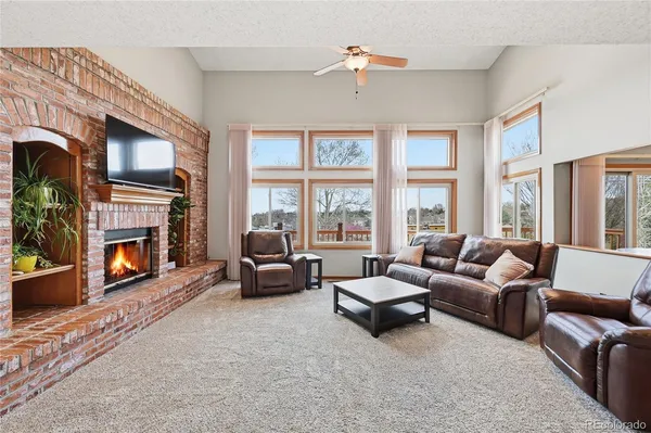 a living room with furniture fireplace and a large window