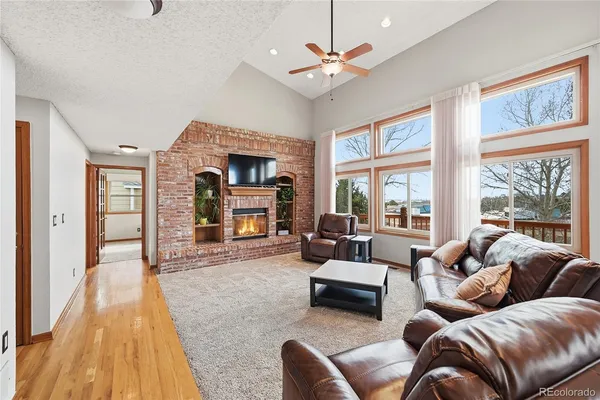 a living room with furniture fireplace and a large window