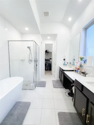 a spacious bathroom with a double vanity sink a toilet a mirror and shower