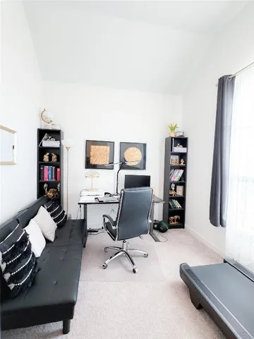 a view of a workspace with furniture and a window
