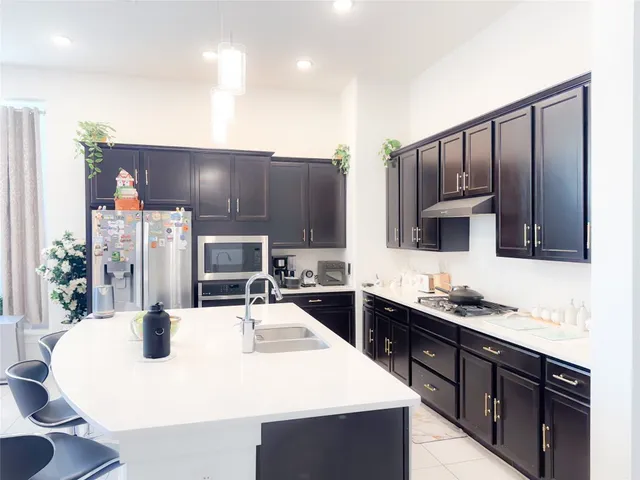 a kitchen with stainless steel appliances a sink and a refrigerator