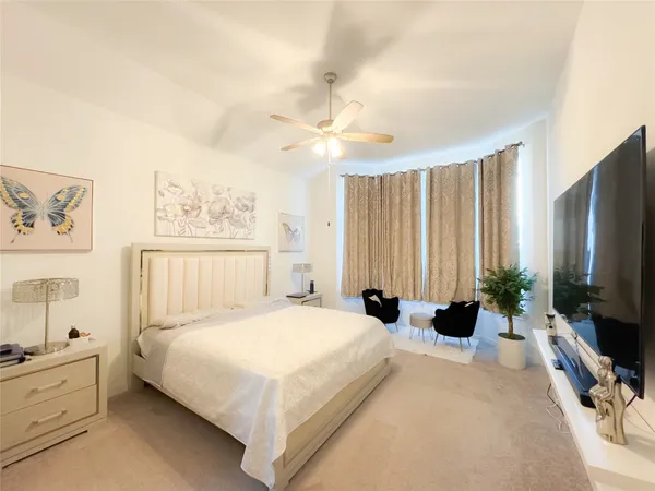 a bedroom with a bed flat screen tv and a chandelier