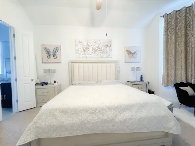 a bedroom with a large bed and a window