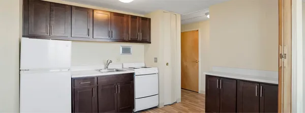 a kitchen with stainless steel appliances granite countertop a sink and cabinets with wooden floor
