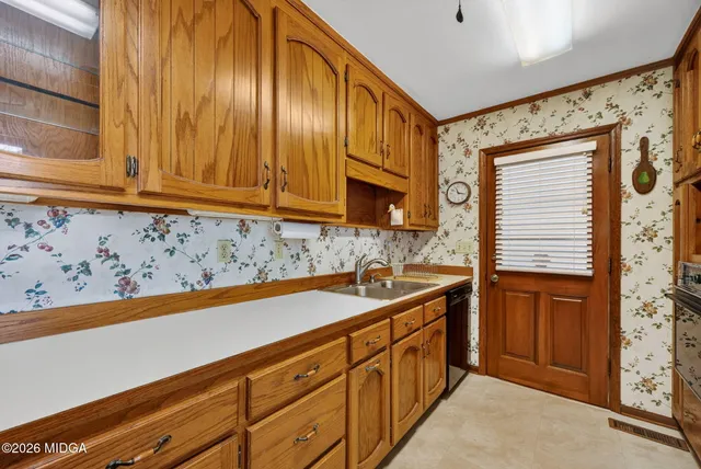 a kitchen with stainless steel appliances granite countertop a sink and dishwasher wooden cabinets