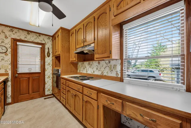 a kitchen with stainless steel appliances granite countertop a sink a stove and a refrigerator