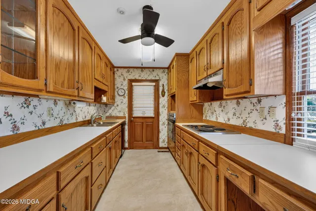 a kitchen with stainless steel appliances granite countertop a sink a stove and a refrigerator