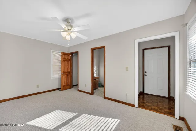a view of an empty room with window and a ceiling fan